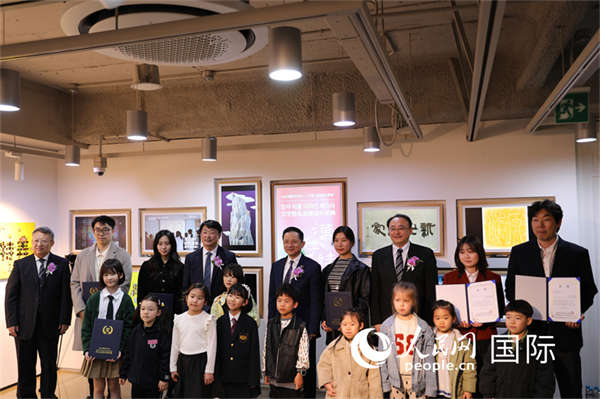 2. 出席活动的嘉宾与“汉字姓名创意设计”获奖者合影。人民网记者 莽九晨摄